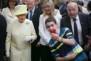 BELFAST, NORTHERN IRELAND - JUNE 24: ילד מפתיע את המלכה על צילום סלפי בעת ביקור רשמי בבלפסט בינואר 2015.